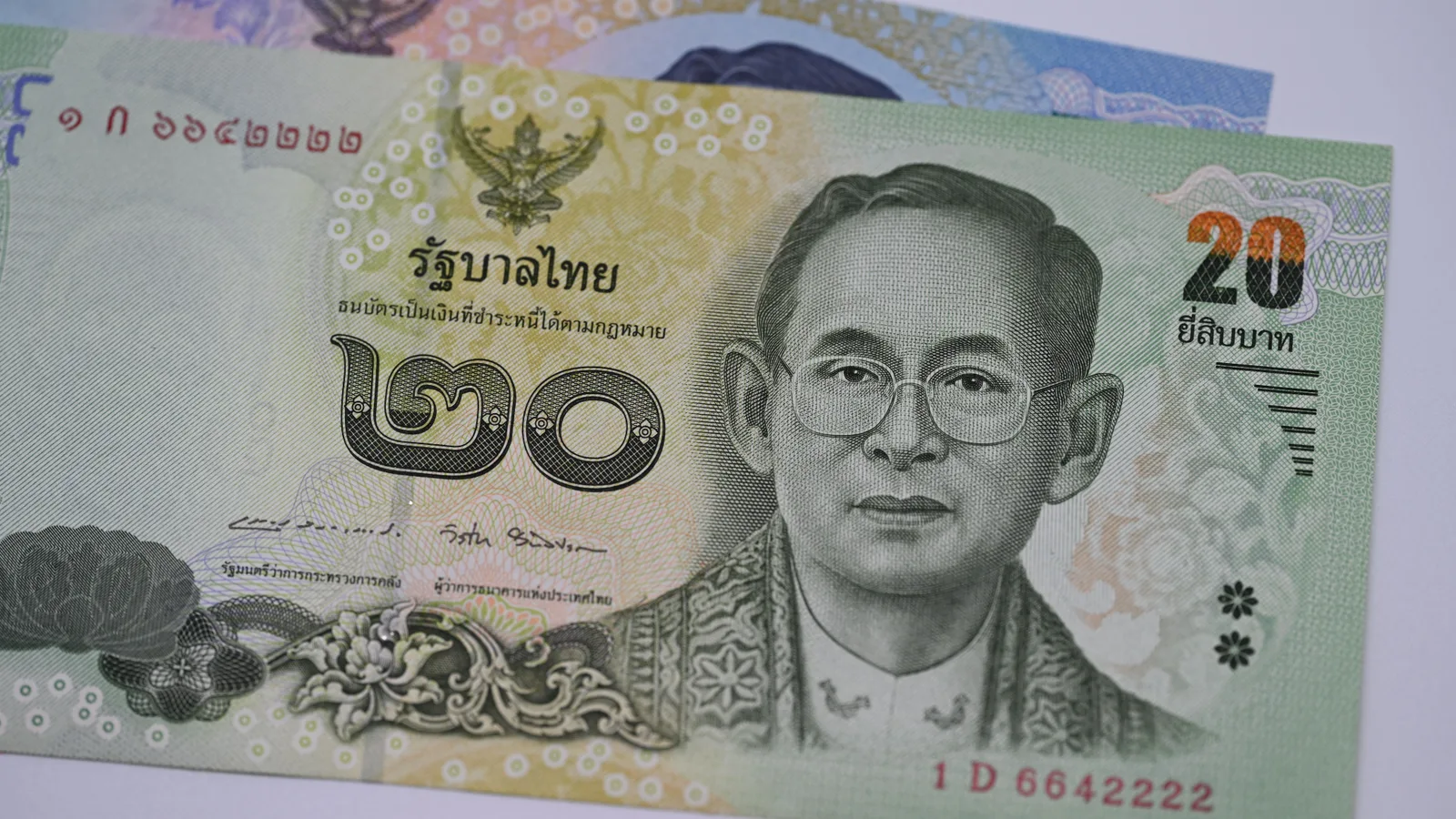 Gros plan sur les détails gravés d'un billet de baht thaïlandais