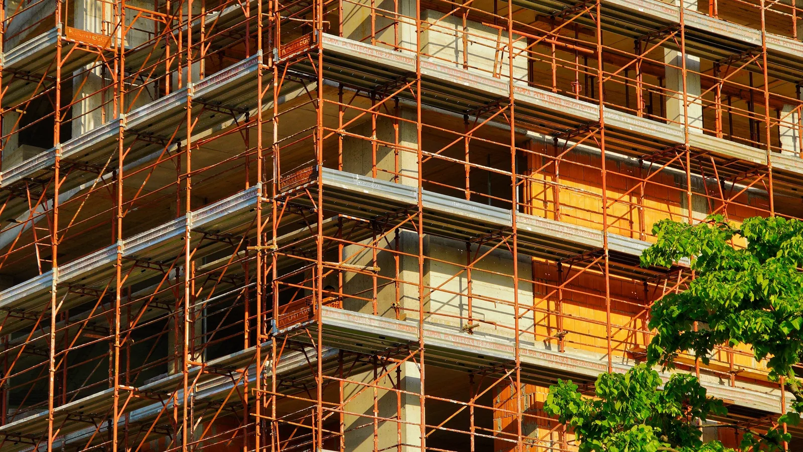 Un bâtiment de faible hauteur enveloppé d'échafaudages en cours de construction